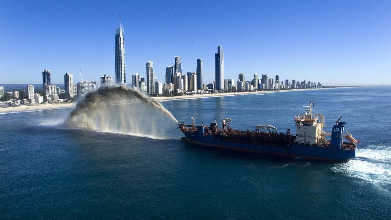A suction hopper dredger is rainbowing sand at Surfers Paradise beach