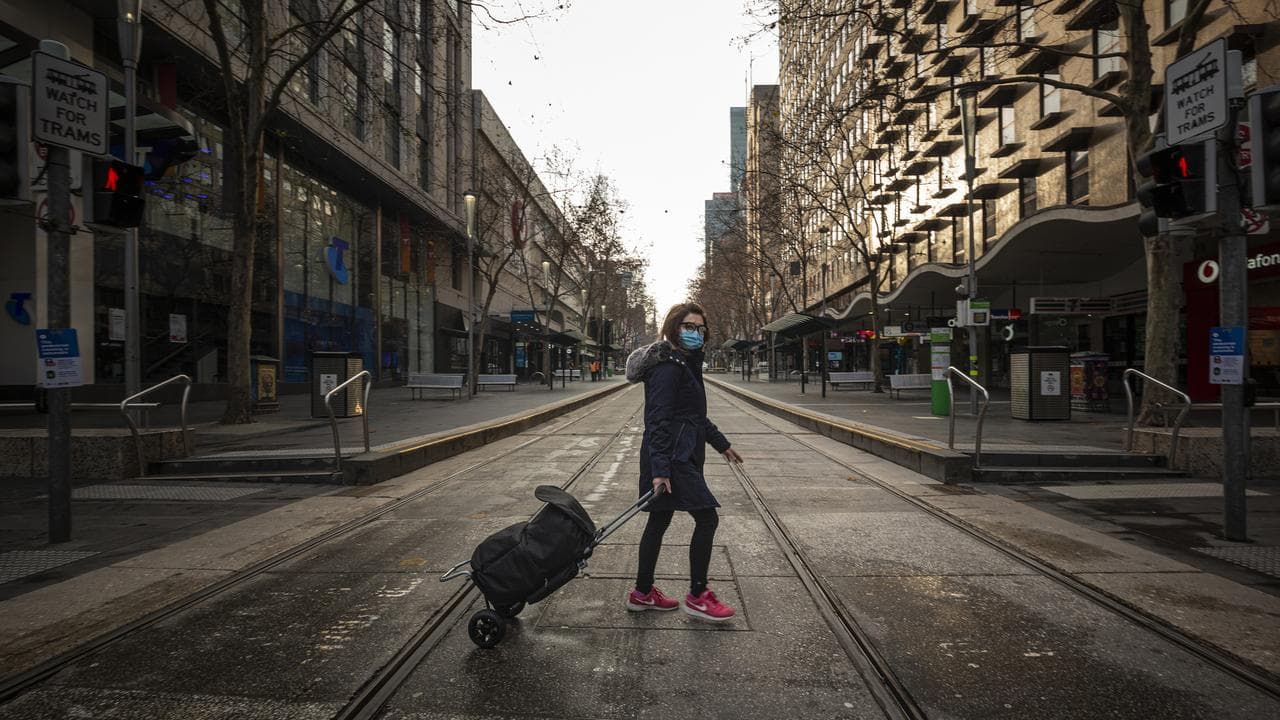 Woman walking an empty Melbourne street during the COVID-19 pandemic
