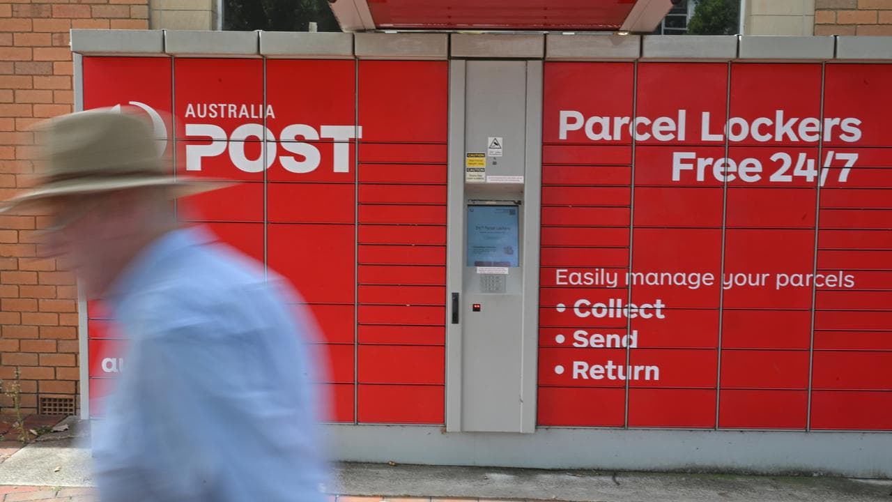 Man walks past Australia Post parcel locker