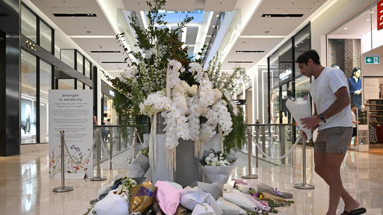 A man lays flowers at a memorial