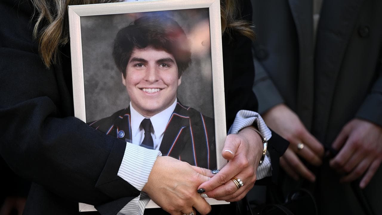 Supporter holds a picture of James Tsindos