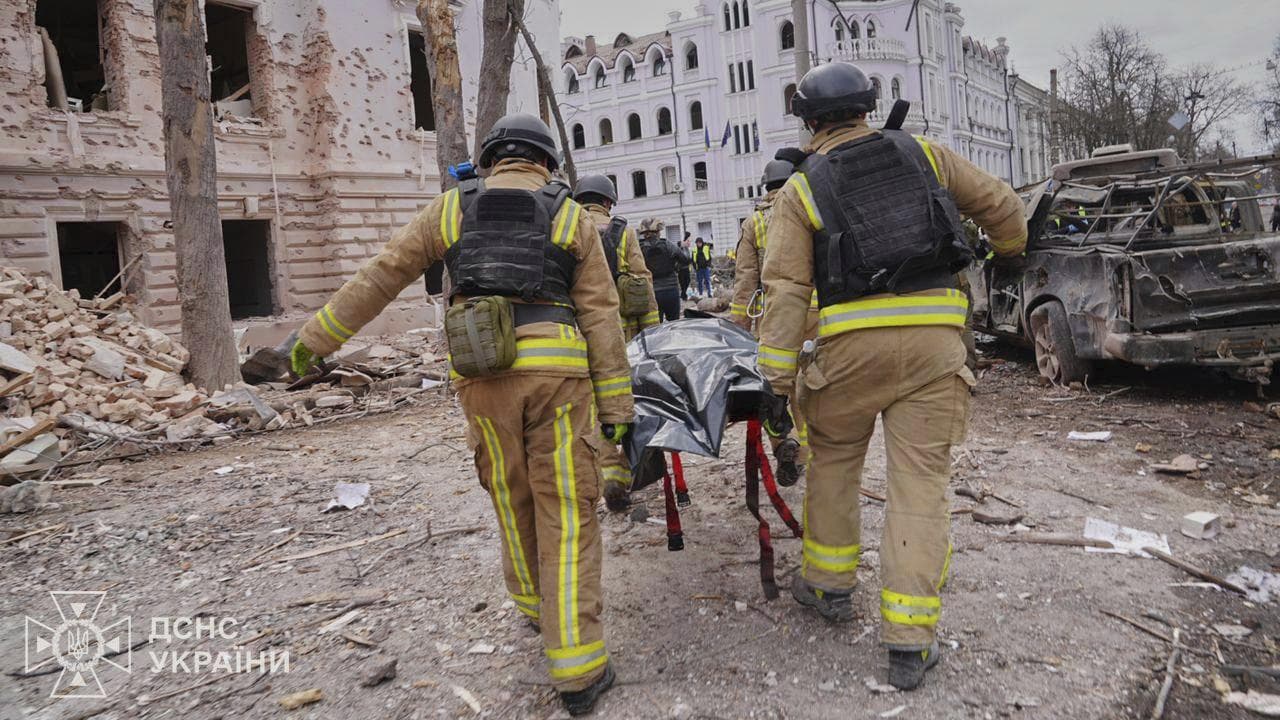 Firefighters carry a body of a victim