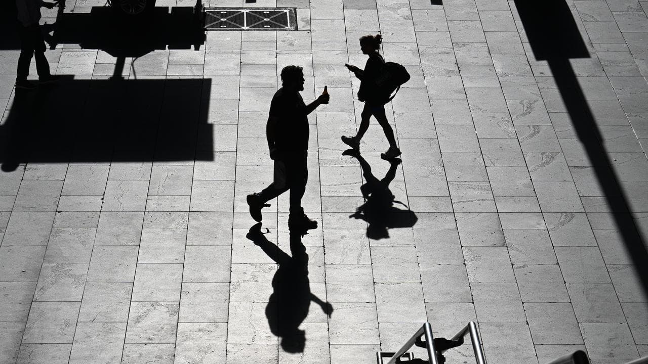 A silhouette of people on their morning commute in Melbourne, Victoria