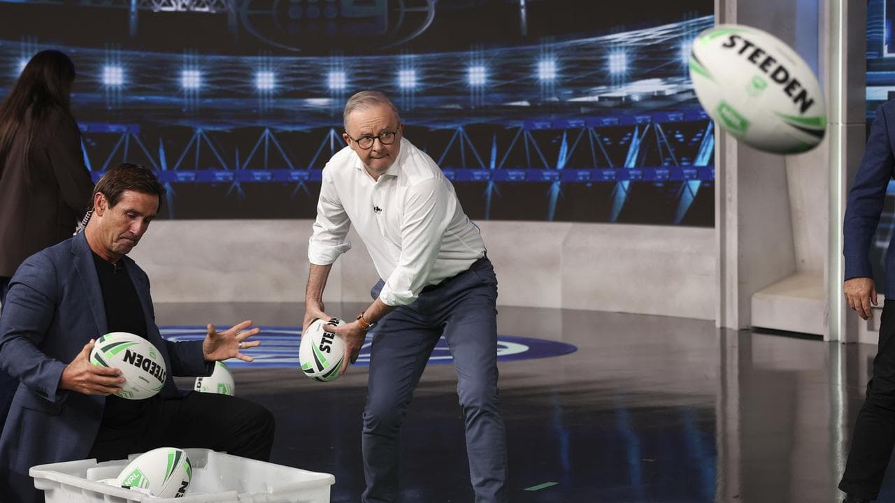 Anthony Albanese passes a football