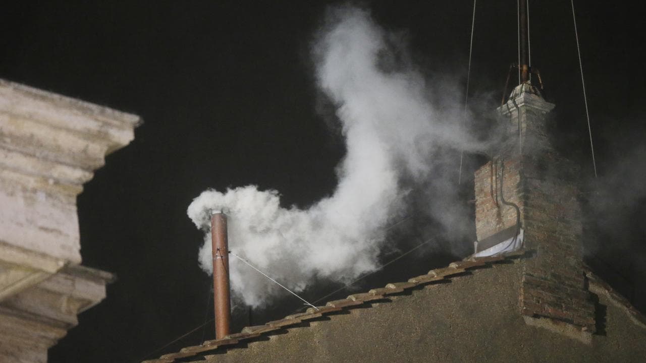 White smoke billowing out from the chimney of the Sistine Chapel
