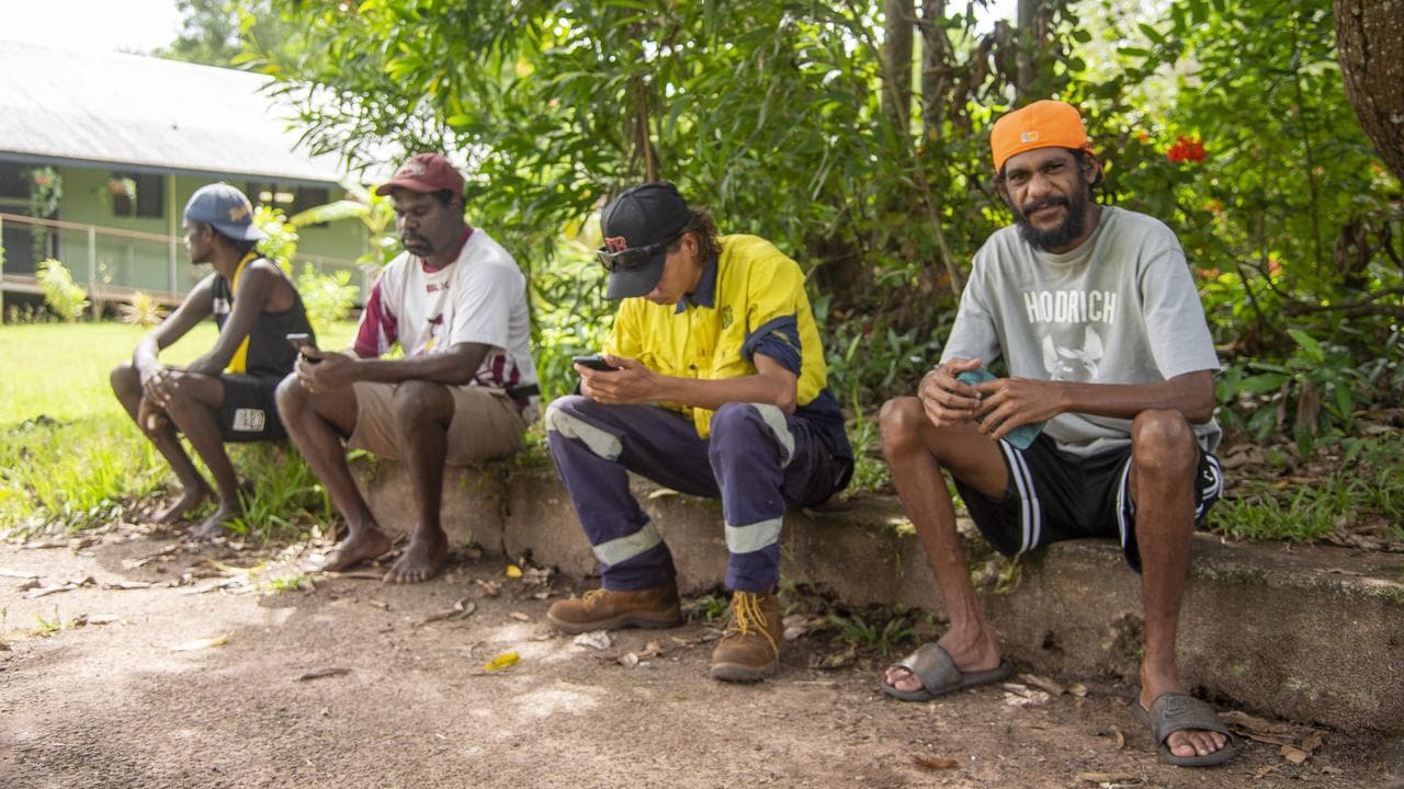 John McLennan Jnr with three other men waiting to vote.