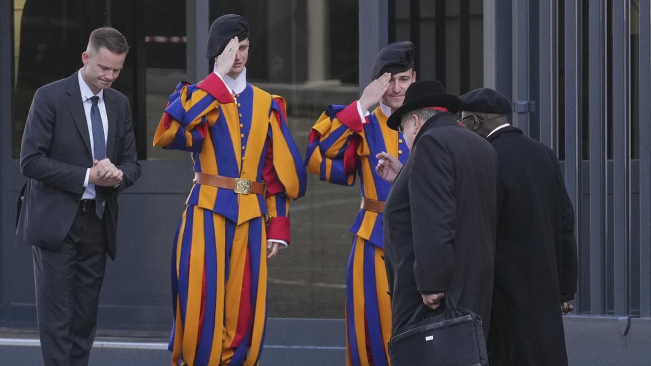 Cardinals, right, arrive for a meeting of cardinals, at the Vatican