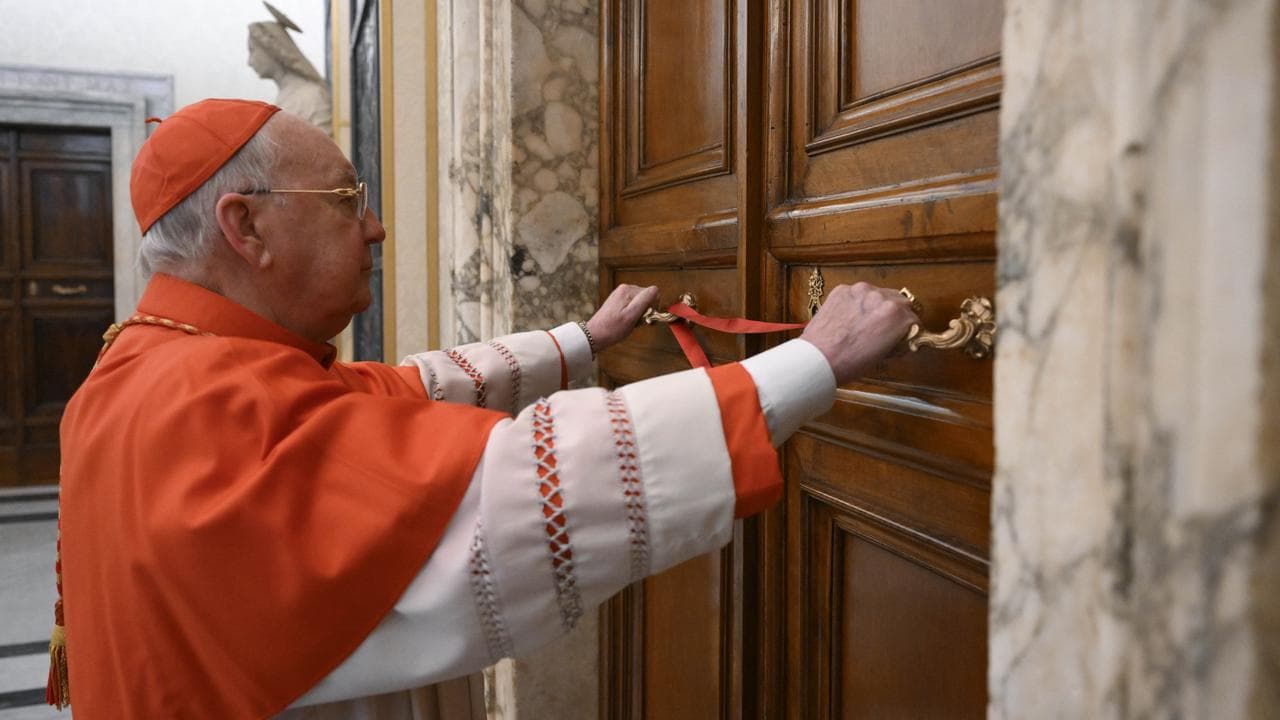 Cardinal Kevin Joseph Farrell seals the door to the papal studio