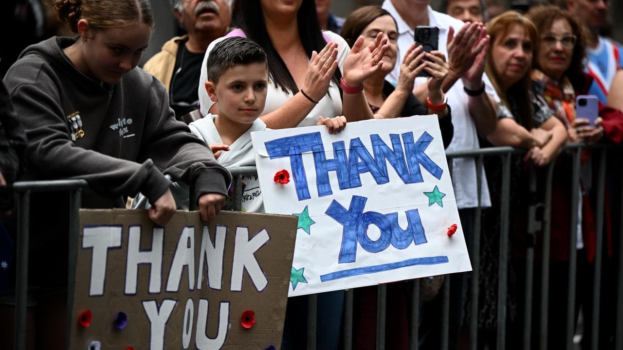People hold signs of gratitude in Sydney