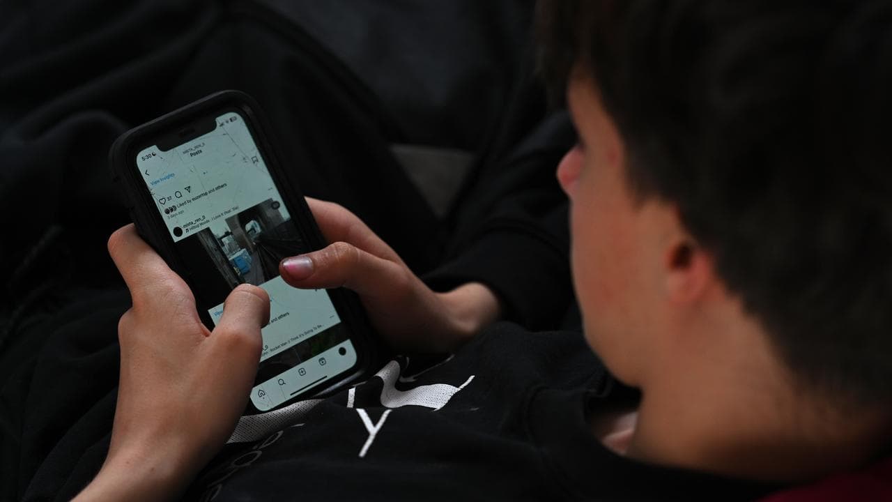 A teenager uses his phone to access social media (file image)