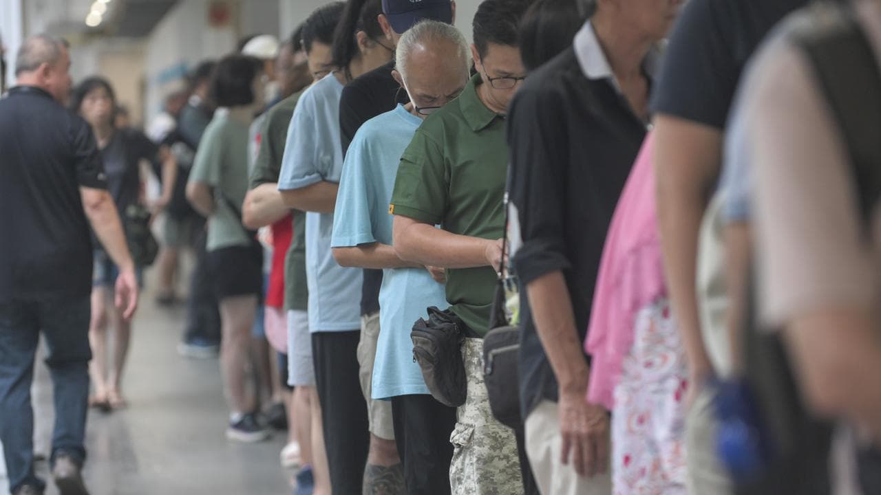 Voters queue to cast their ballots at a polling station in Singapore