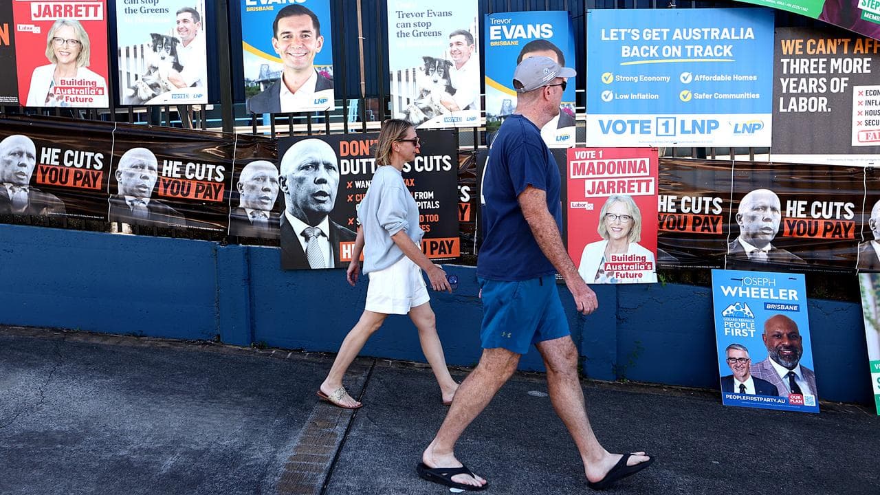 Voters walking past corflutes on election day