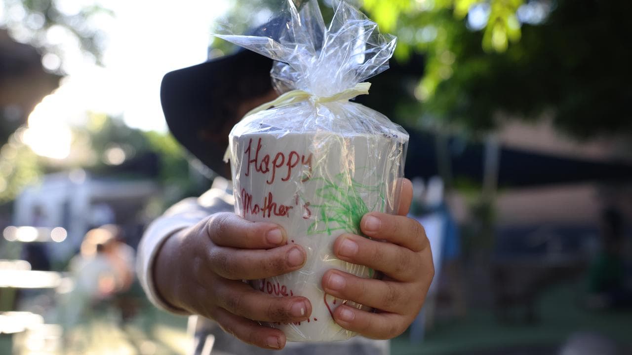 A child is seen with a Mother's Day gift in Sydney