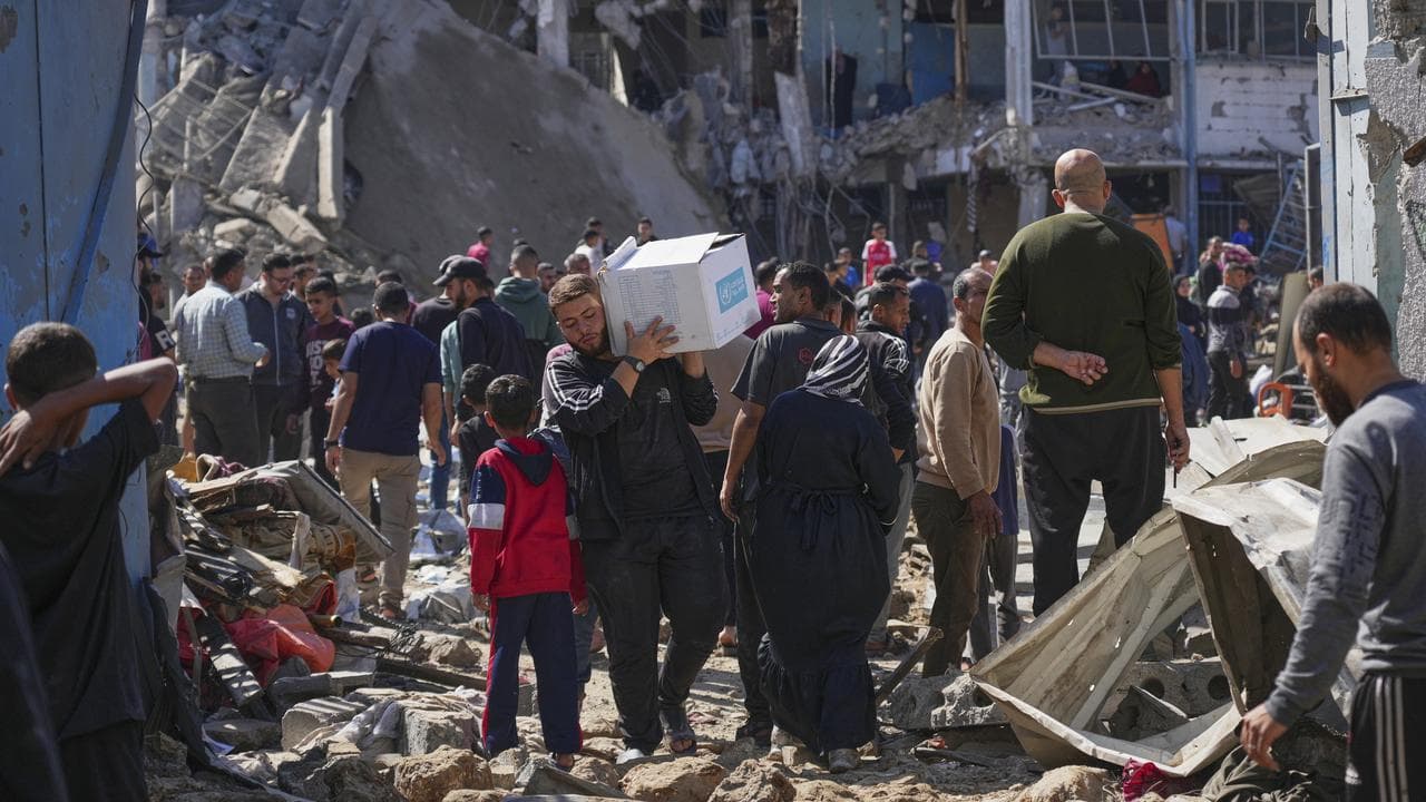 Palestinians collect belongings from a school shelter in Bureij, Gaza