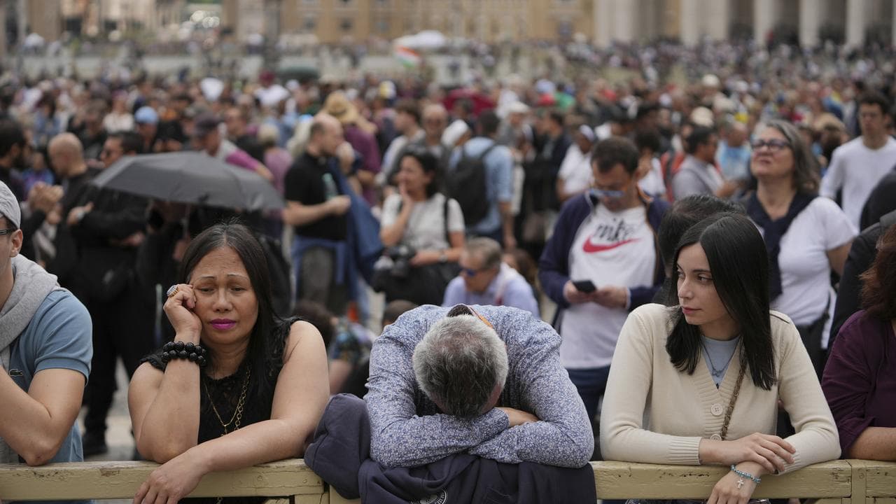 People in St Peter's Square wait to see smoke from the Sistine Chapel