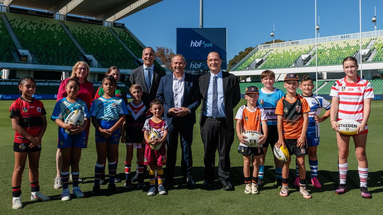 Politicians, NRL officials and children pose for a photo.
