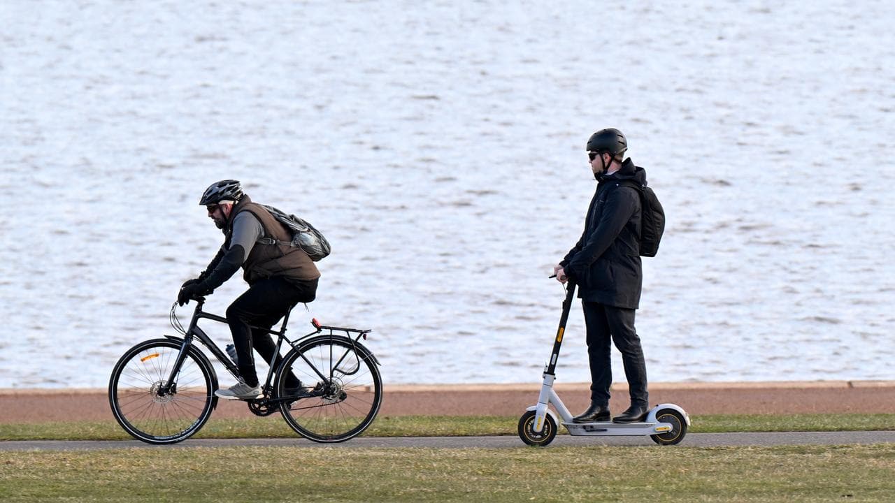Men ride a bike and an e-scooter