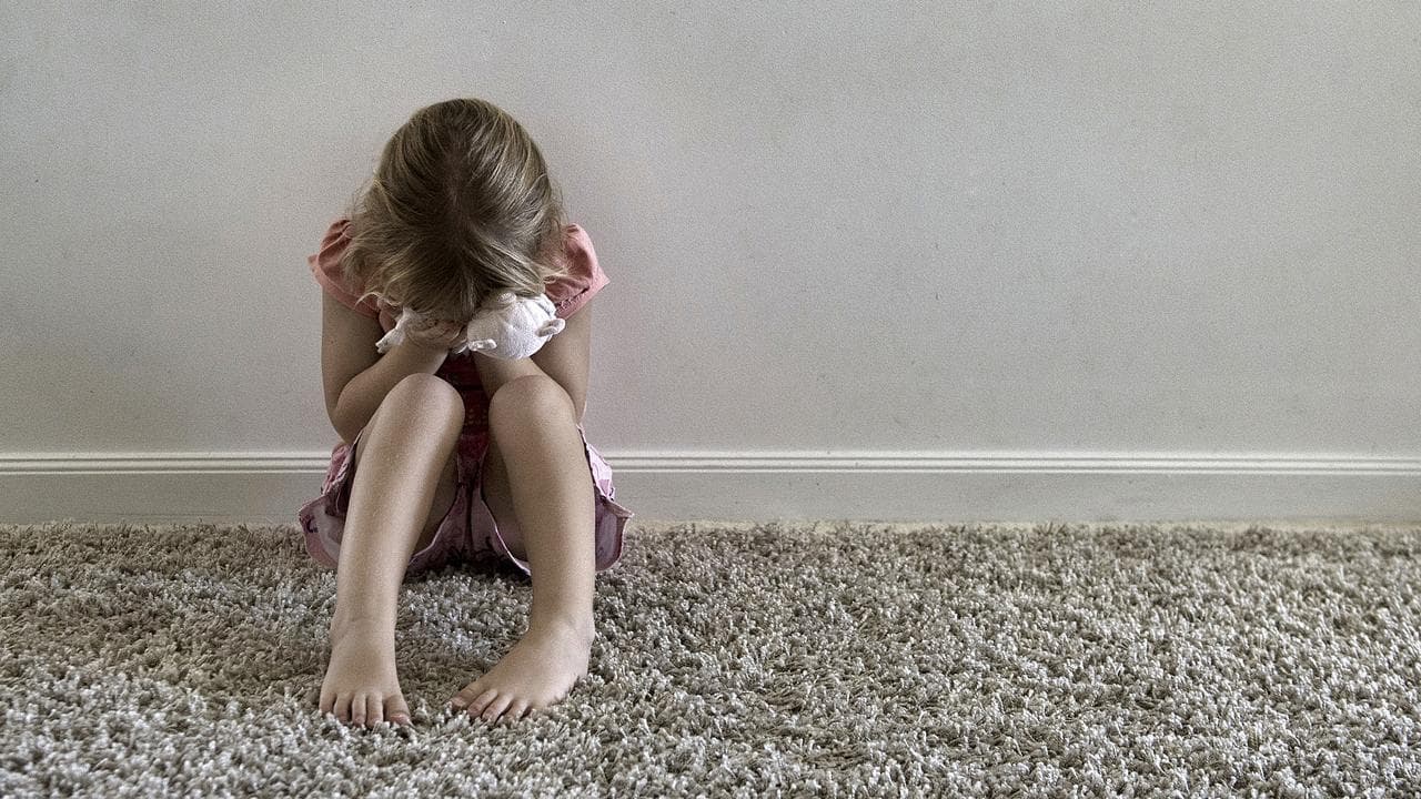 A child hugs a stuffed toy