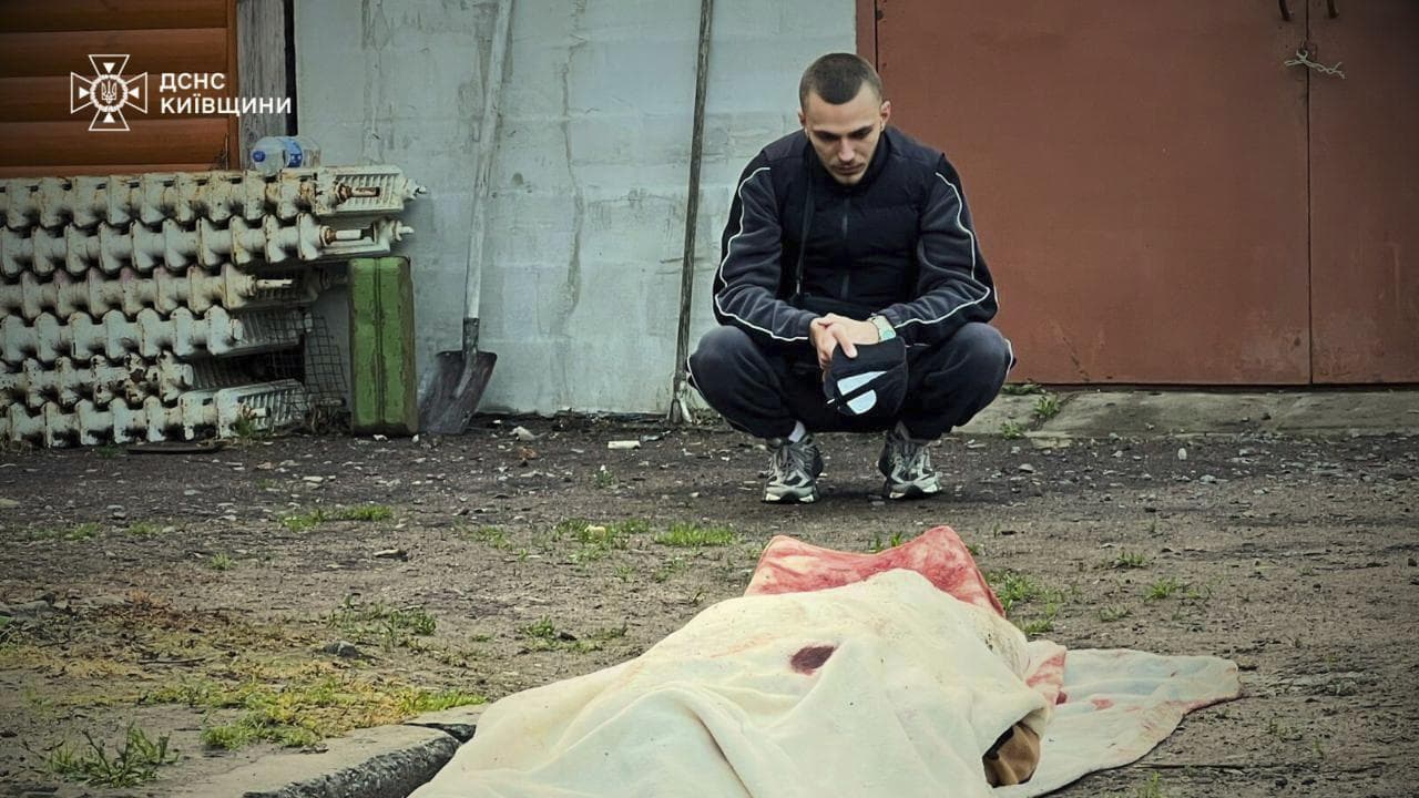 Man looking over the body of a person killed in a drone attack