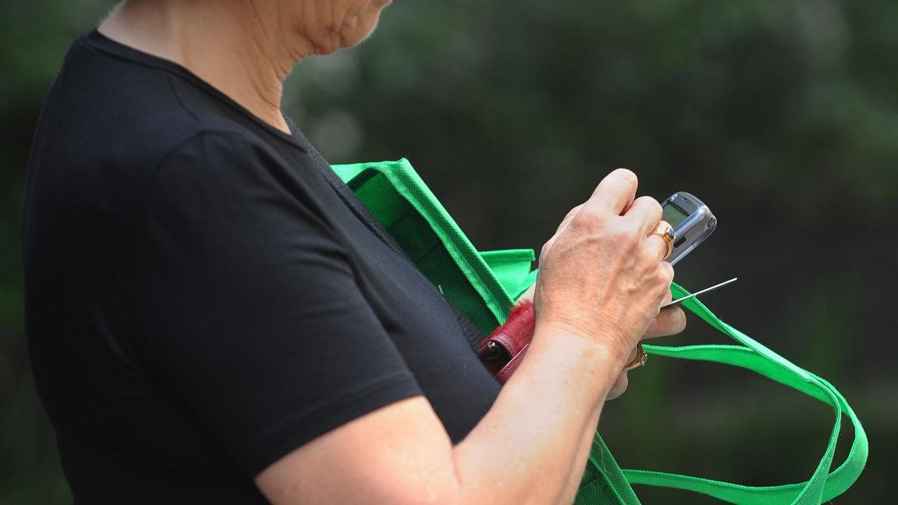 Woman types on mobile phone