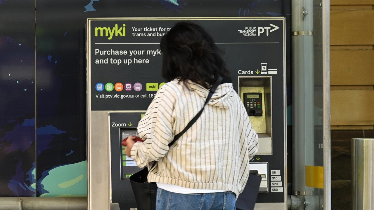 A woman using a Myki terminal