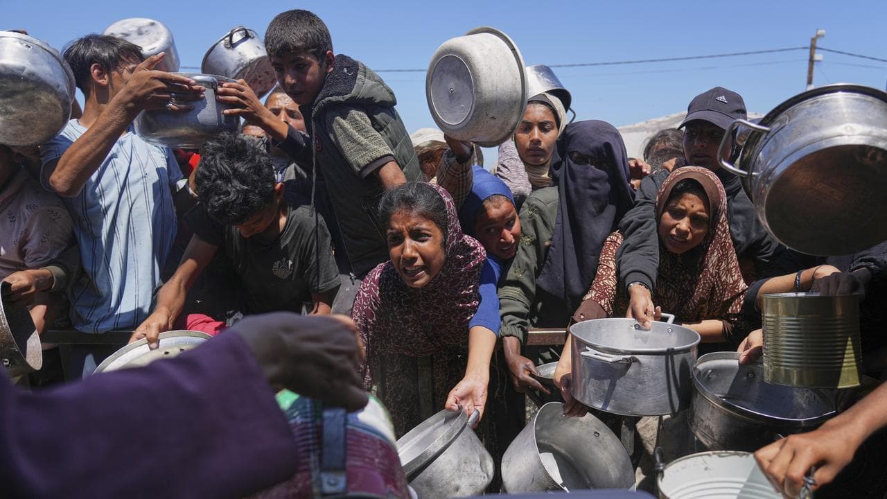 Palestinians struggle to receive cooked food in Gaza