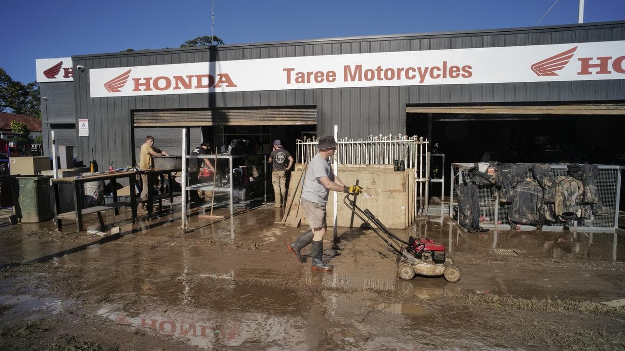 Residents are seen cleaning up after floods in Taree, NSW