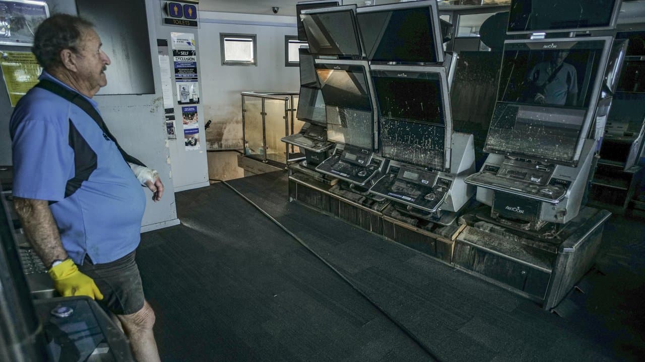 Lawrie Dege cleans up at the Sailo's club after floods in Taree, NSW