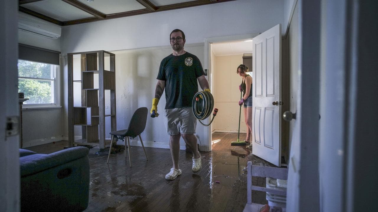 Damian Newell cleans up after floods in Taree, NSW