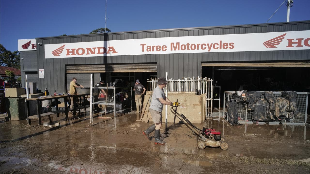 Local residents are seen cleaning up after floods in Taree