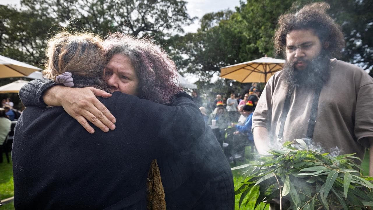 Nadeena Dixon (centre) conducts a smoking ceremony