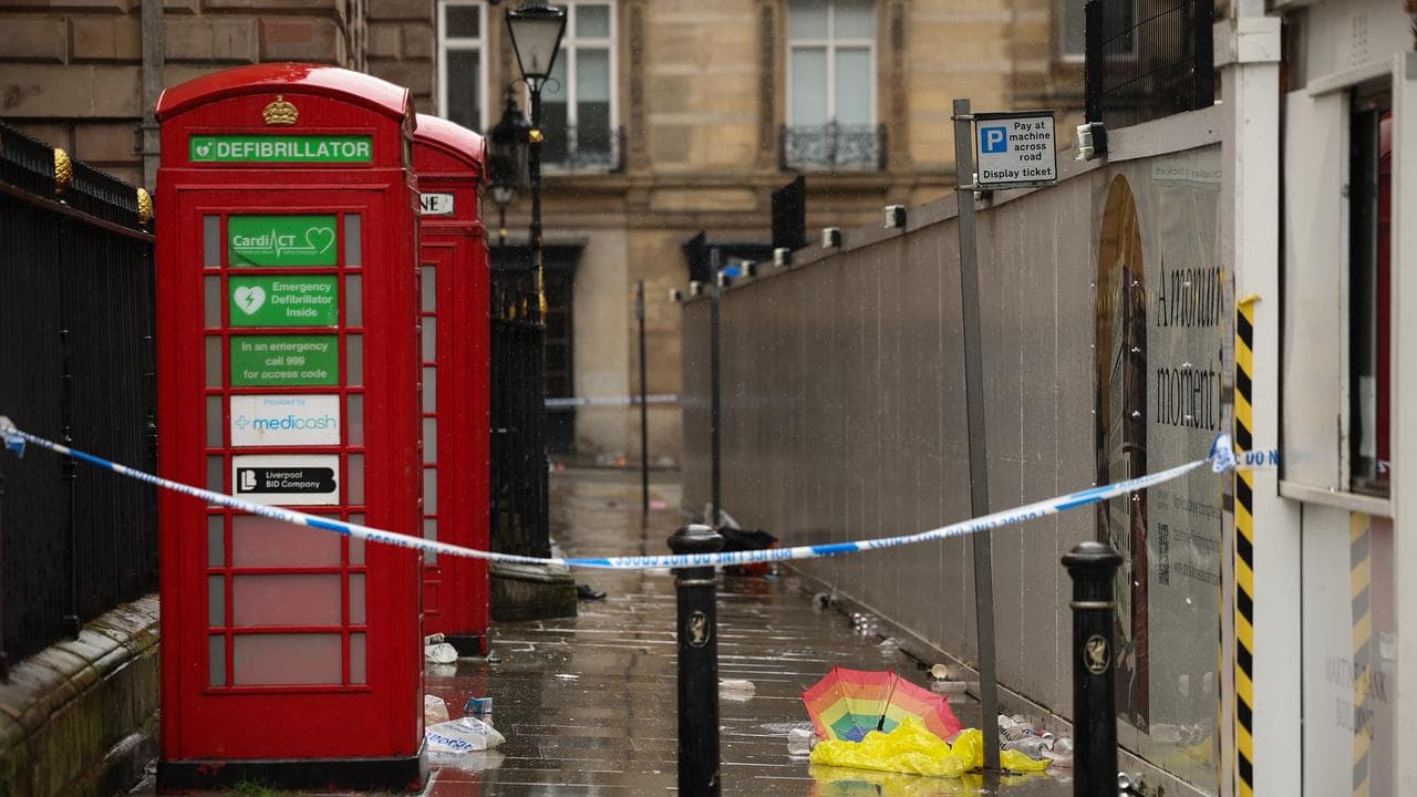 An umbrella lies on the floor inside the police cordon