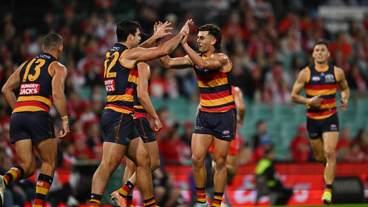 Adelaide teammates rush to congratulate Josh Rachele (second right)