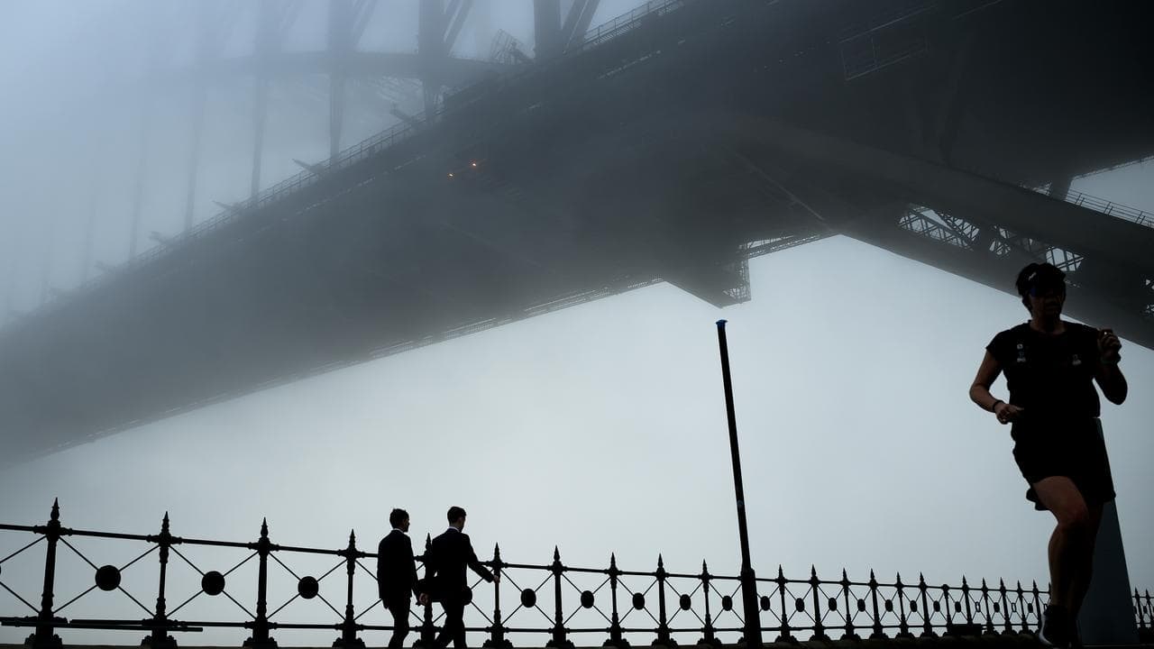 The Sydney Harbour Bridge disappears under fog