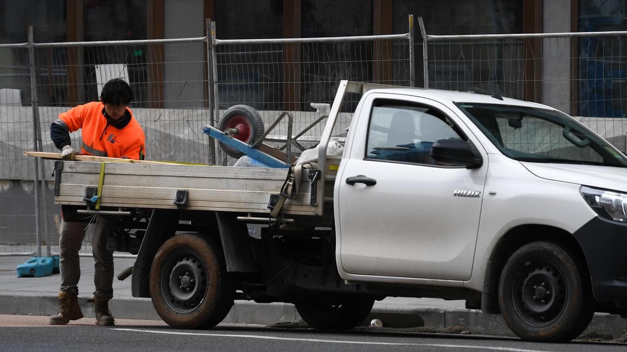 A construction worker loading a ute
