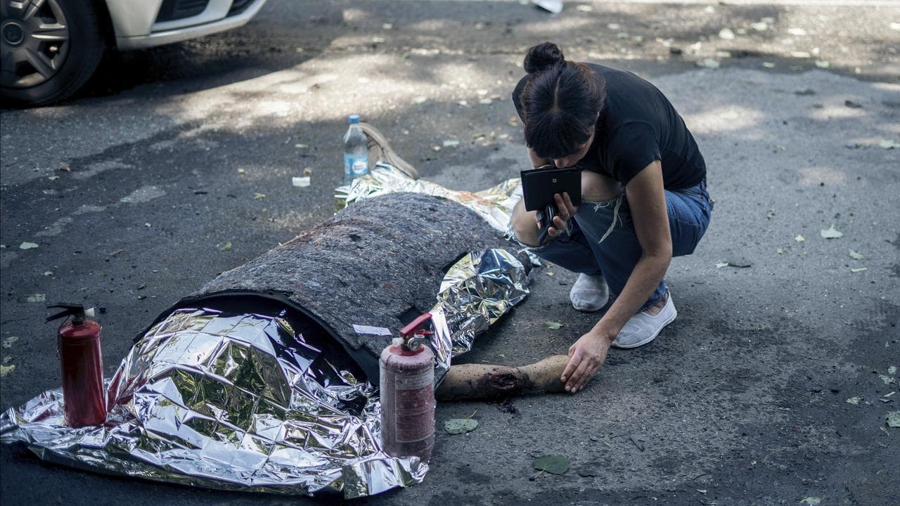A woman with the body of a relative killed in a Russian strike on Sumy