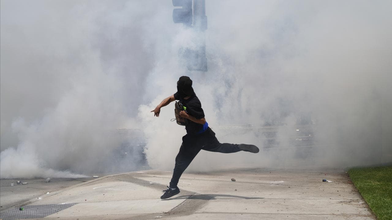 A protester throws a rock at law enforcement during a demonstration 