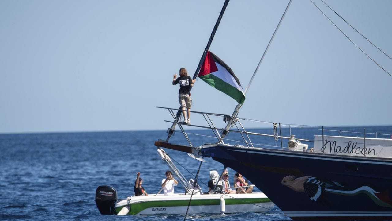 Activist Greta Thunberg stands near a Palestinian flag on a boat