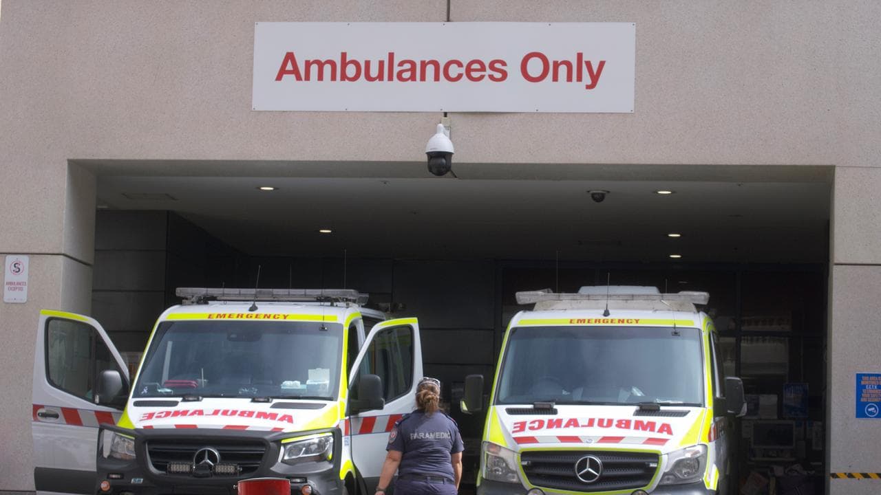 Paramedics at ambulances outside a hospital