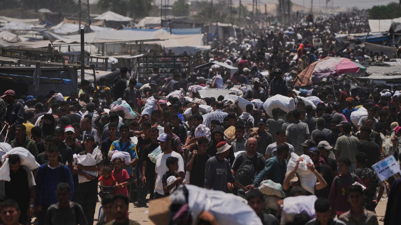 Palestinians carry bags containing food and humanitarian aid packages