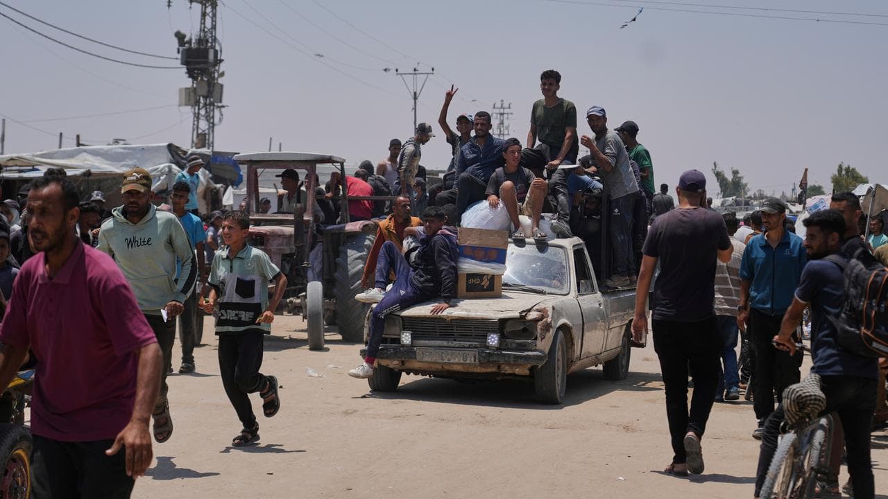 Palestinians carry food and humanitarian aid packages in Gaza