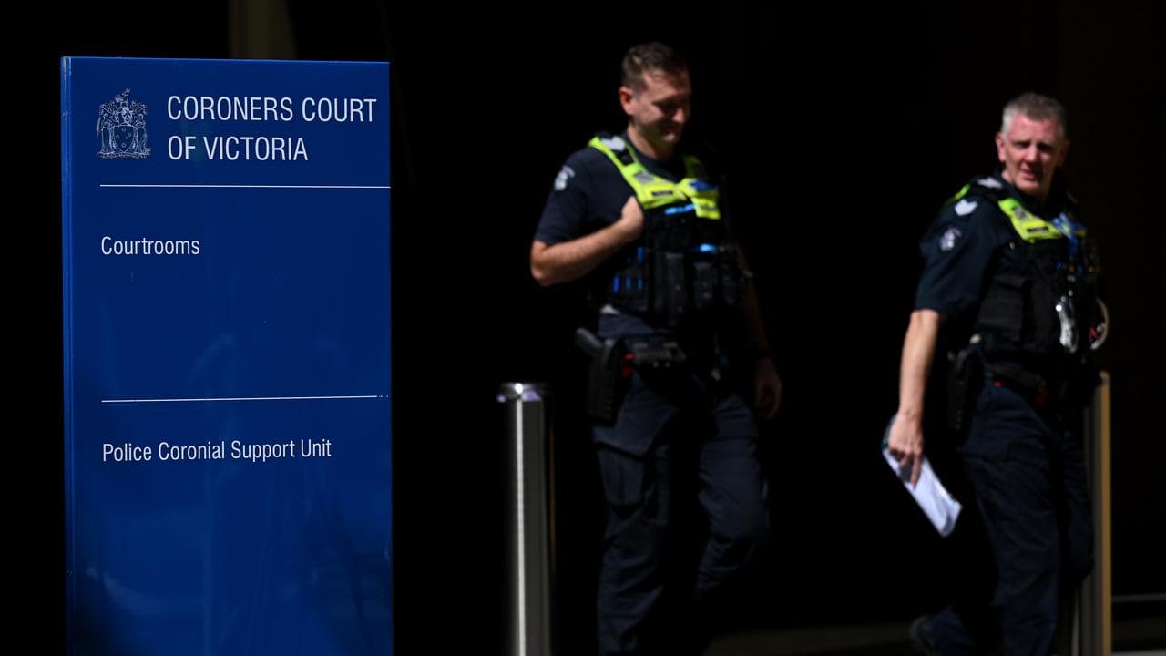 Police next to signage for the Coroners Court (file image)