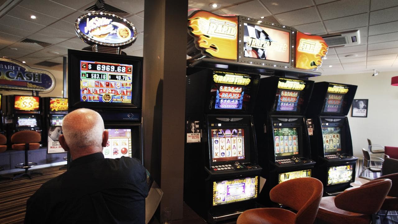 A man plays a pokie machine (file image)