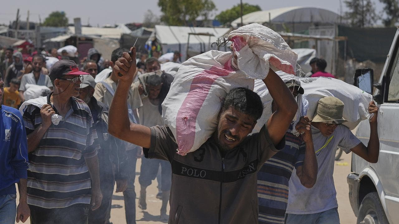 Palestinian carries bag of food from the Gaza Humanitarian Foundation