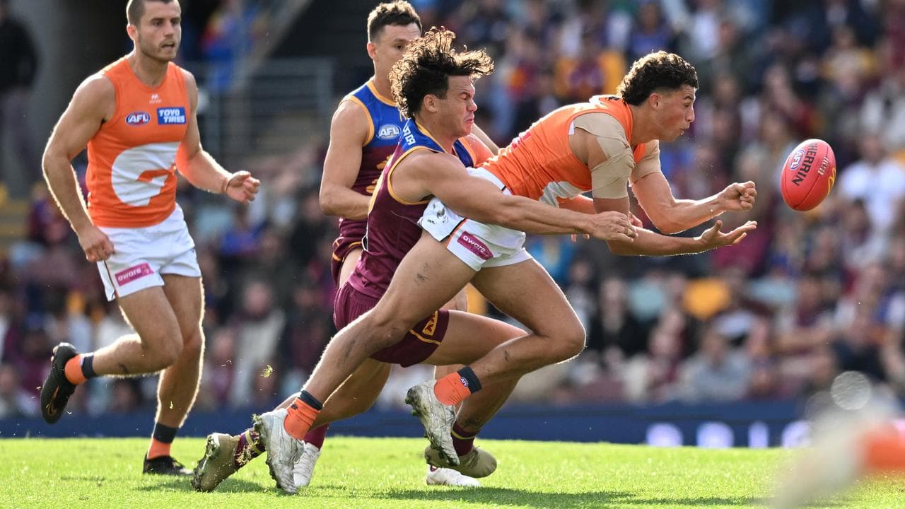 The Giants' Finn Callaghan (right) gets away a handball.