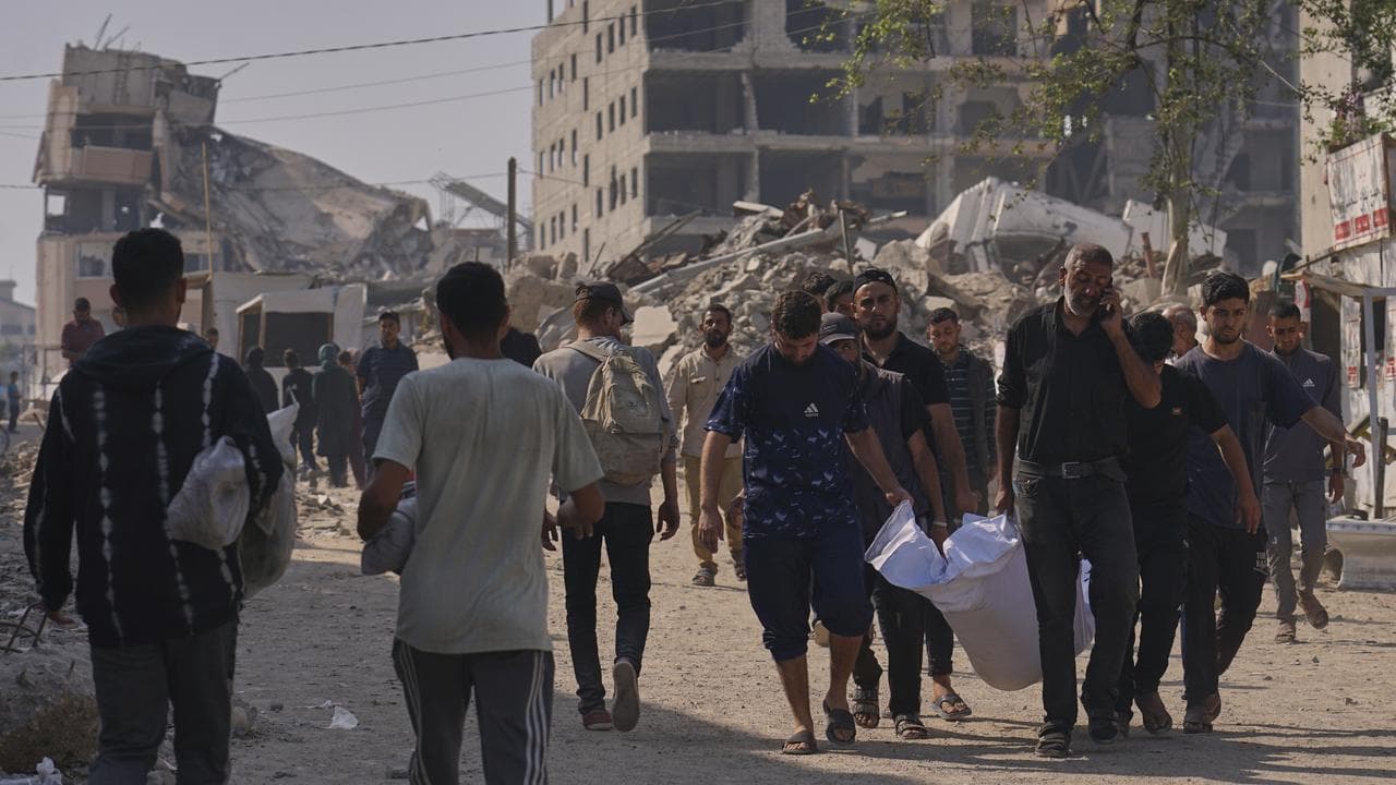 Palestinians carry a person who died trying to access to aid