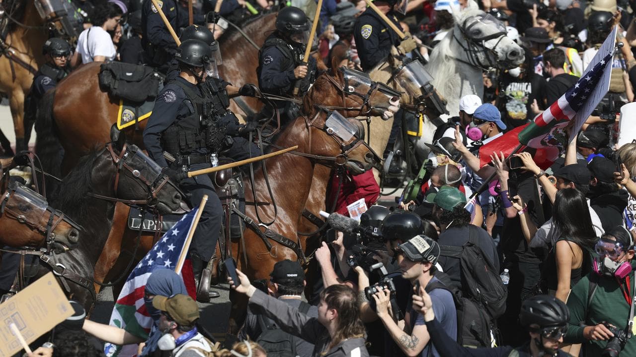 Demonstrators standoff against law enforcement on horseback in LA