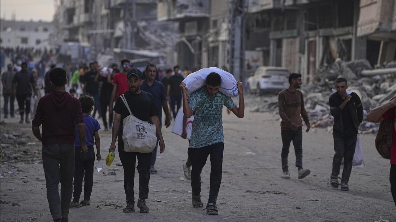 Palestinians carry sacks of food and humanitarian aid in Gaza