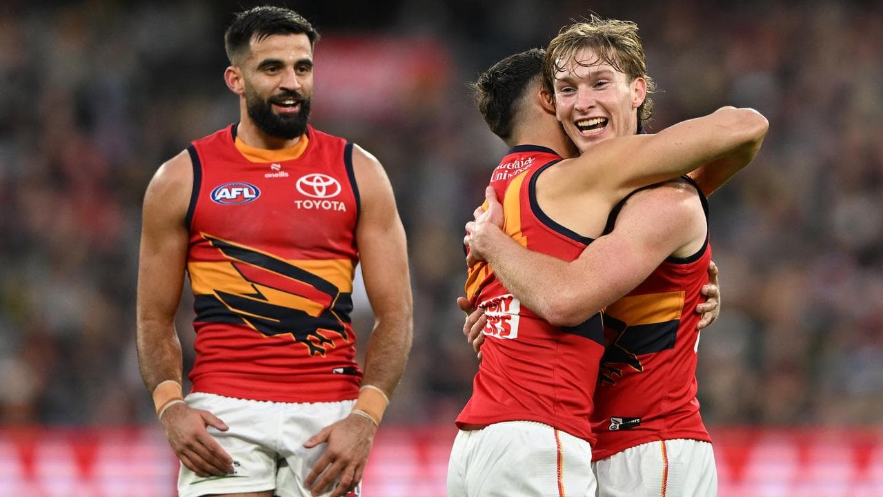 Max Michalanney of the Crows (right).