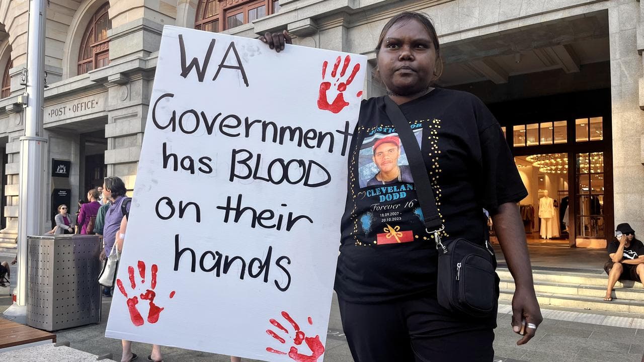 Woman holding sign blaming government
